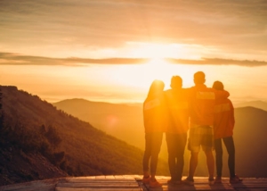 People Standing on the top of a Mountain during Sunset